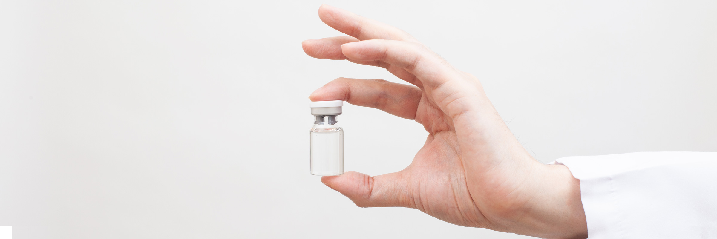 doctor's hand holding a medical vial