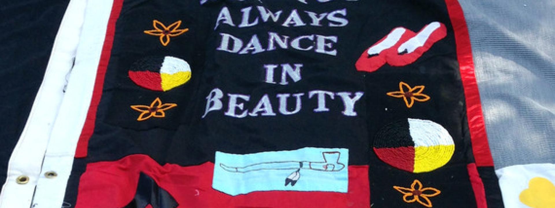 Red and black AIDS quilt panel with ballet shoes, peace pipe, stars and moon