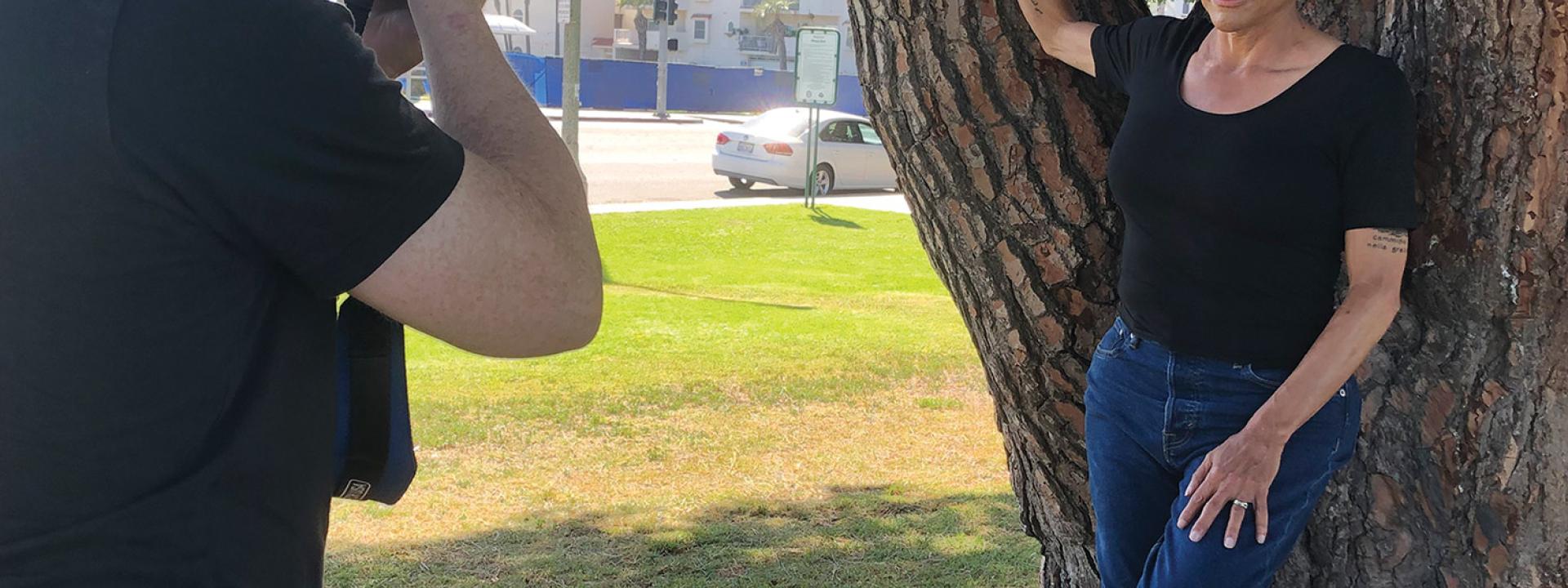 Transgender actor Alexandra Billings leaning against a tree while posing for a photographer