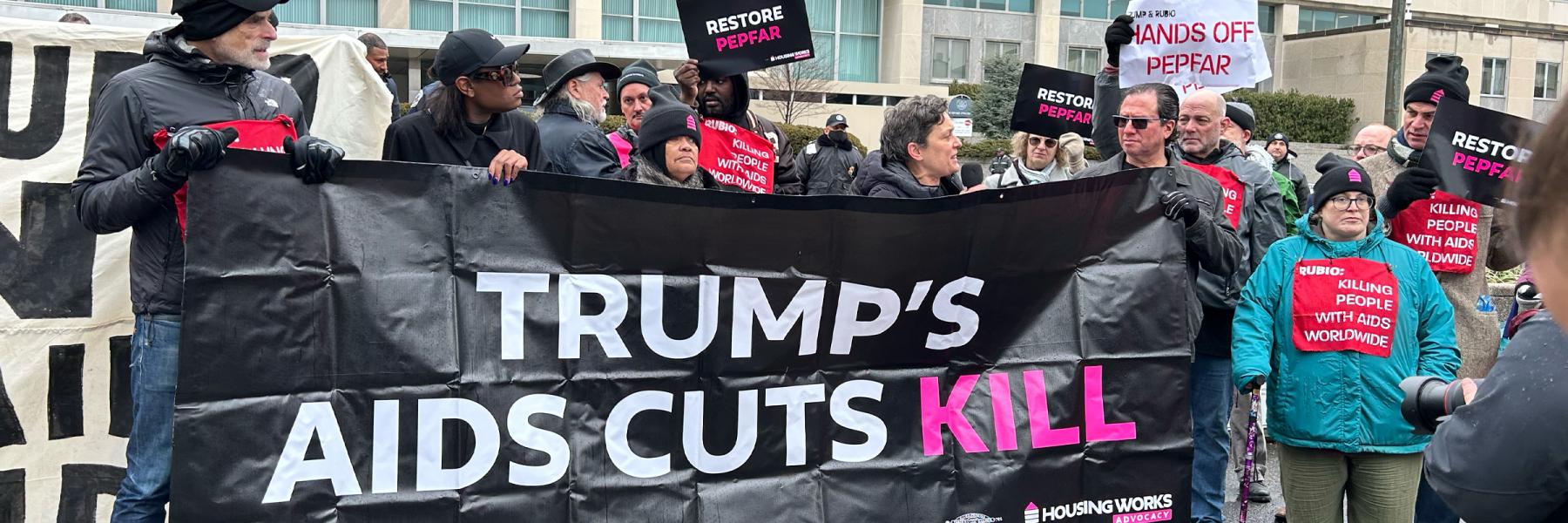 HIV activists holding banners and signs at protest against Trump's freeze on PEPFAR assistance