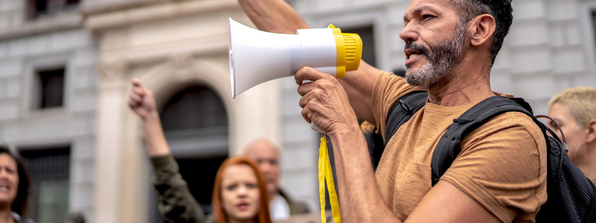 picture of a black man yelling into a bullhorn during a political protest