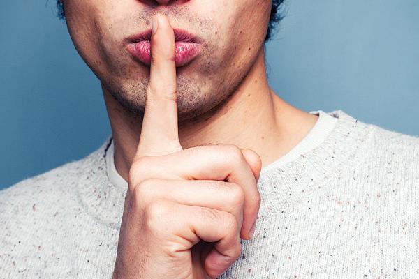 Young person hold a finger in front of lips in SHHH motion