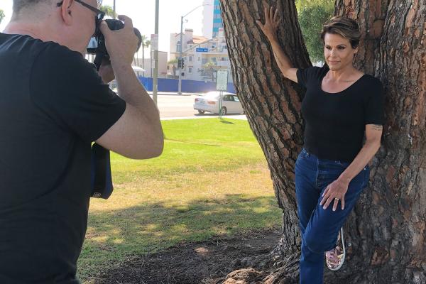 Transgender actor Alexandra Billings leaning against a tree while posing for a photographer